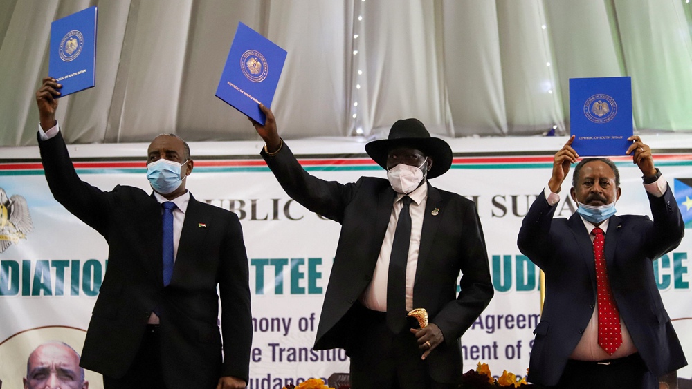 Sudan's Sovereign Council Chief General Abdel Fattah al-Burhan (L), South Sudan's President Salva Kiir (C), and Sudan's Prime Minister Abdalla Hamdok lift copies of a signed peace agreement with Sudan's five key rebel groups in Juba, South Sudan, August 31, 2020. /Reuters